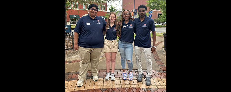 2 female and 2 male student leaders stand for a group picture outside before leading a campus tour