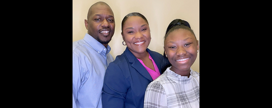 A female student stands with relatives for a closing ceremony picture