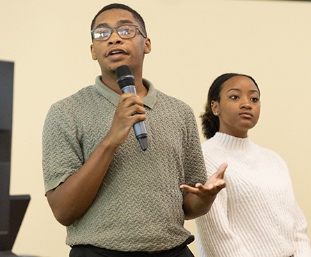 a young person speaking into a microphone making a presentation