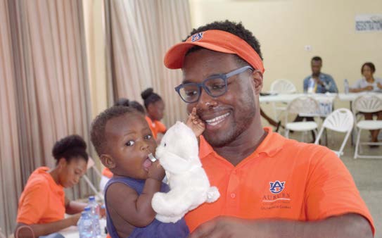 Man holding a child with a stuffed animal
