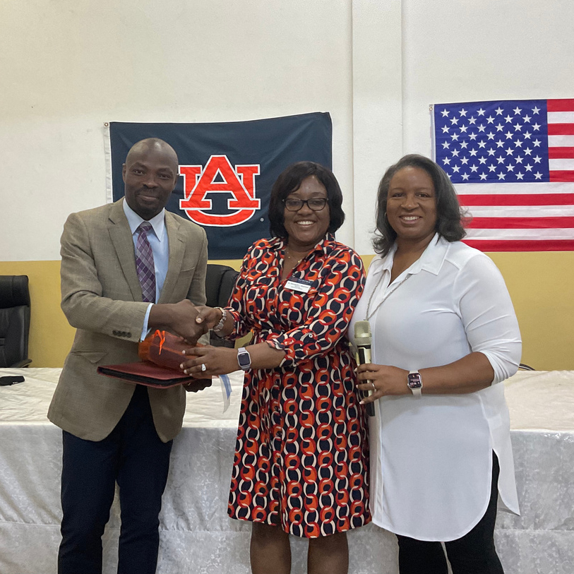 Dr. Quansah (center) and Dr. Baker (right) present gift to Mr. Yacoubou Amadou (left), Deputy Director of the Benin Ministry of Development (MDC).