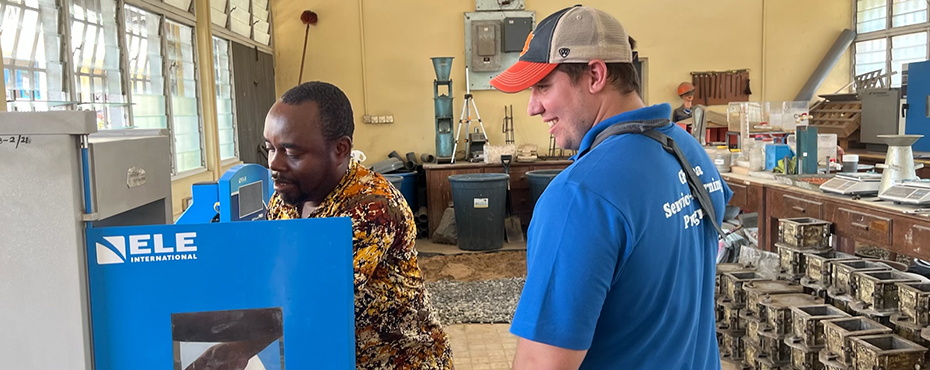 One man shows another man how a machine works