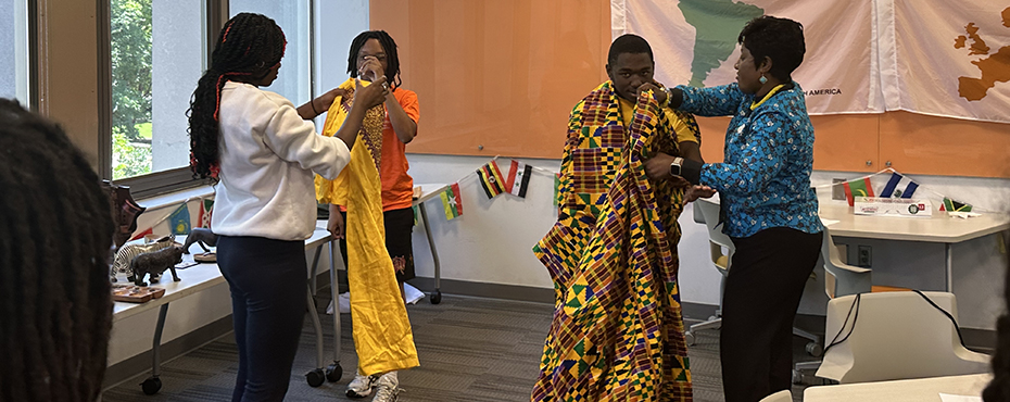 Students being dressed in Ghanaian cultural attire.