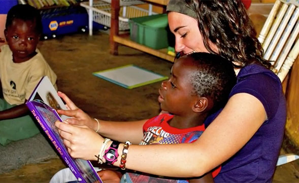woman holding a child on her lap reading a book