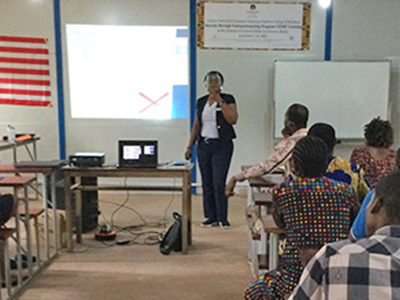 Woman stands in front of class and speaks about entrepreneurship