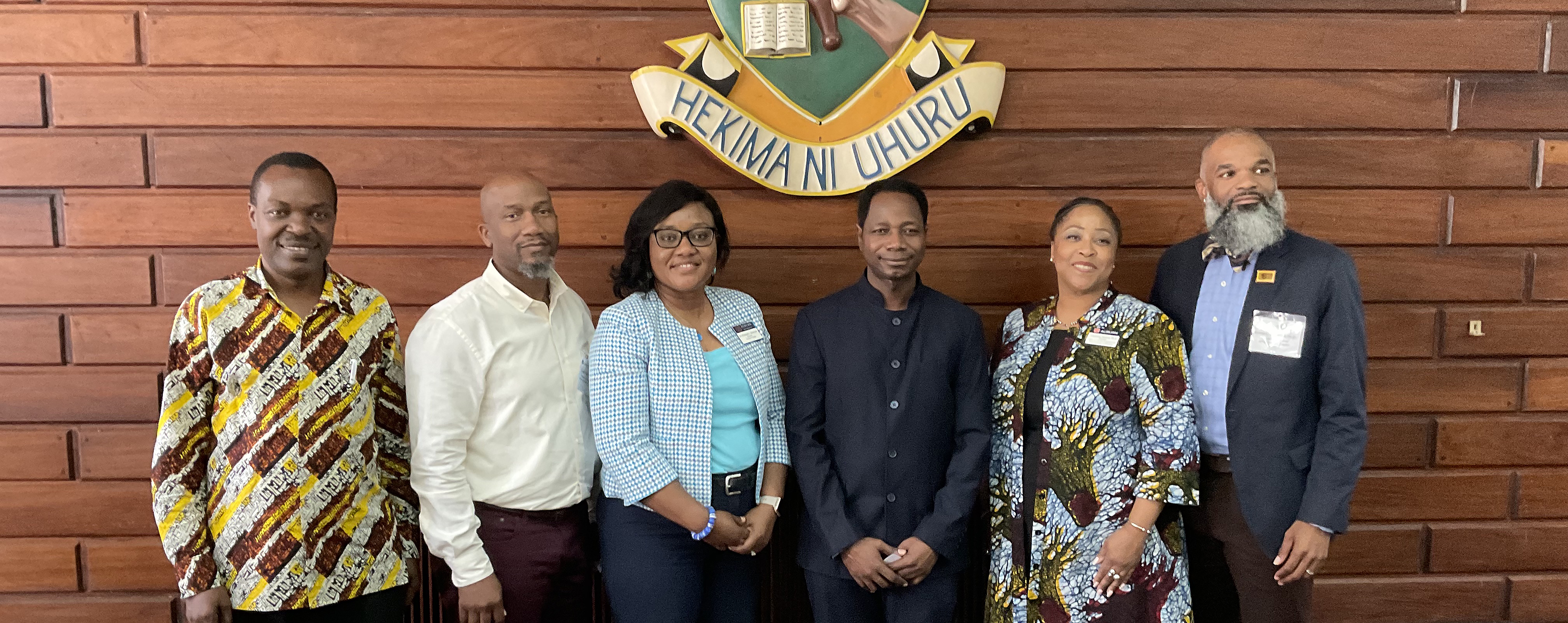 Four men and two women pose for a photo.