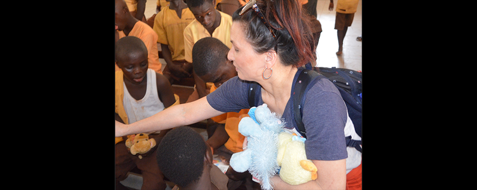 female handing out stuffed toys to children