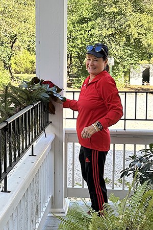 Gail is all smiles as she adds greenery to the porch at Sunny Slope. 