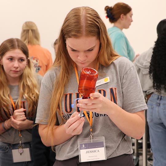 Female student measuring out liquid medication
