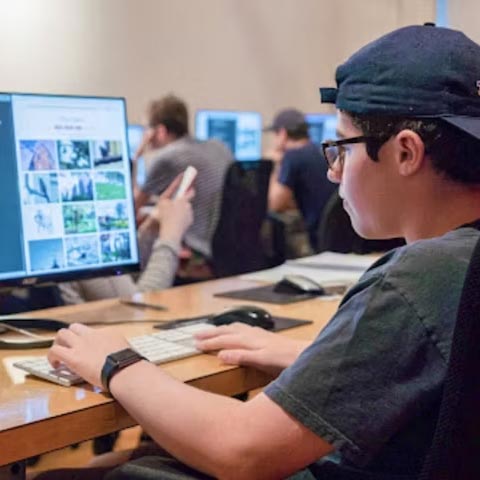 Male student working on a computer editing pictures.