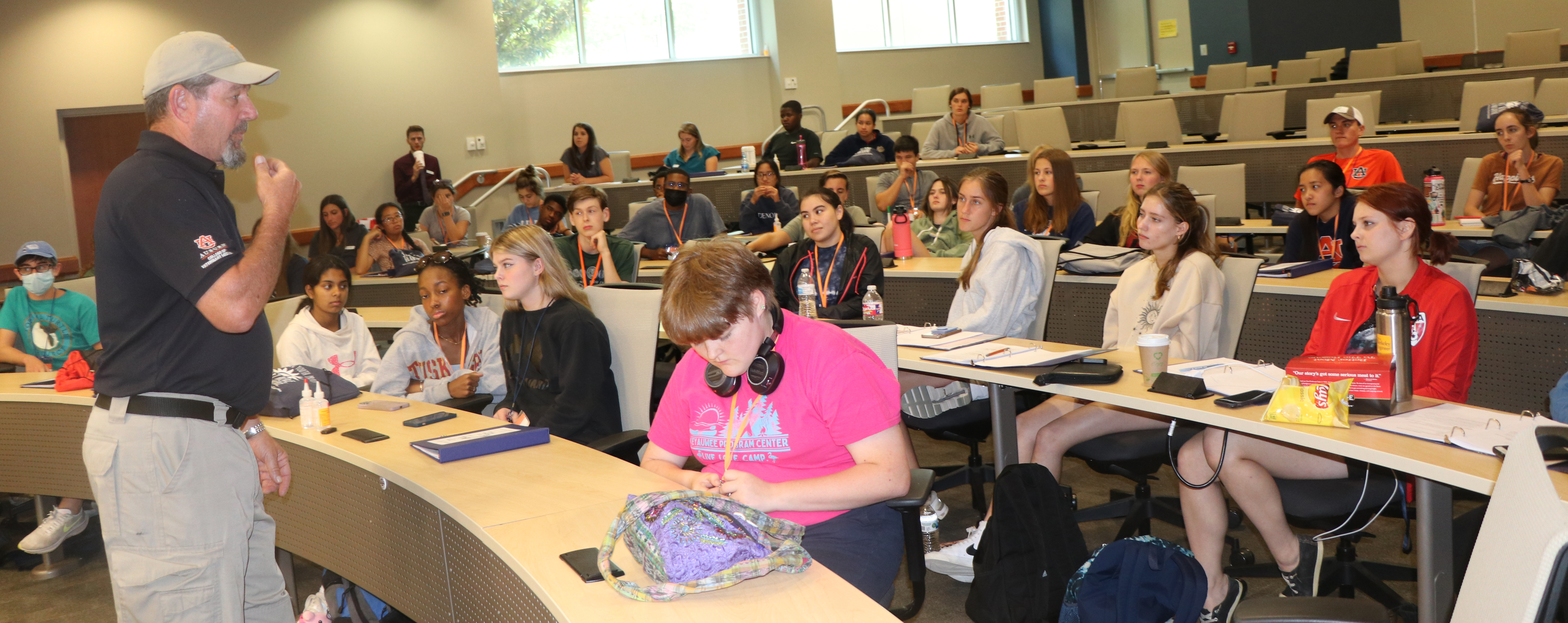 Students sit in an auditorium as they listen to an Auburn University canine specialist.
