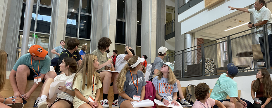 Students sit in the Mell Classroom building while sketching for a project.