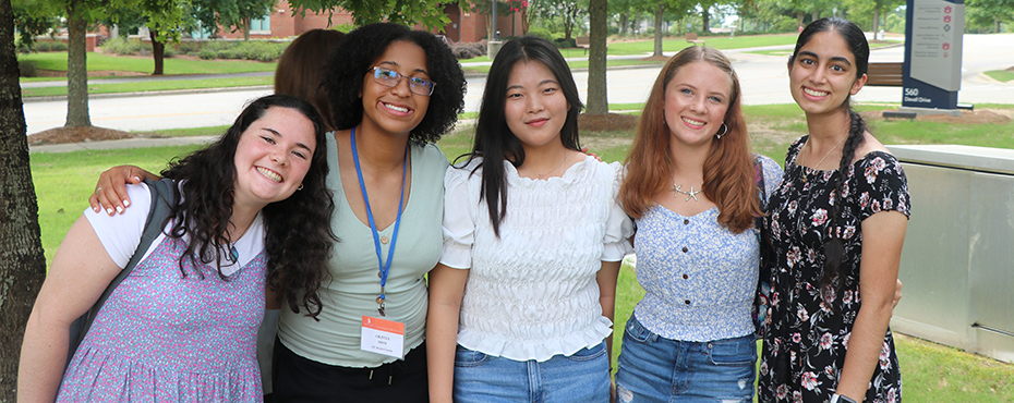 Four female campers smile for a photograph.