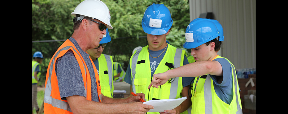 Students looking at building plan with instructor