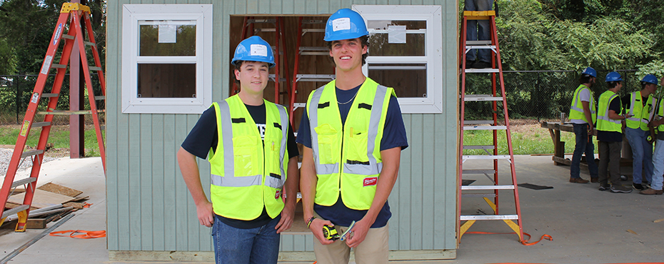 Students posing in front of construction project