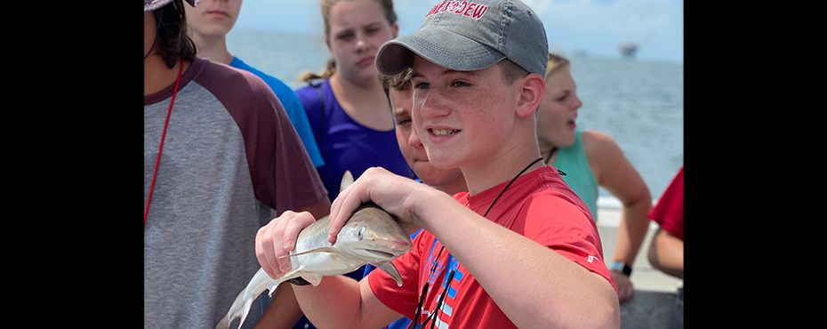 Student holding a small shark
