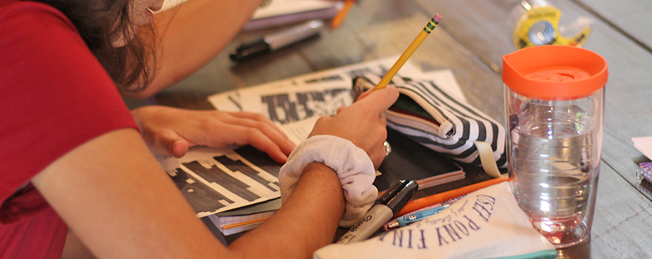 Student writing at desk