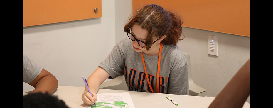 Female student works on paper at desk