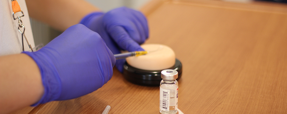 Student practicing giving a vaccine