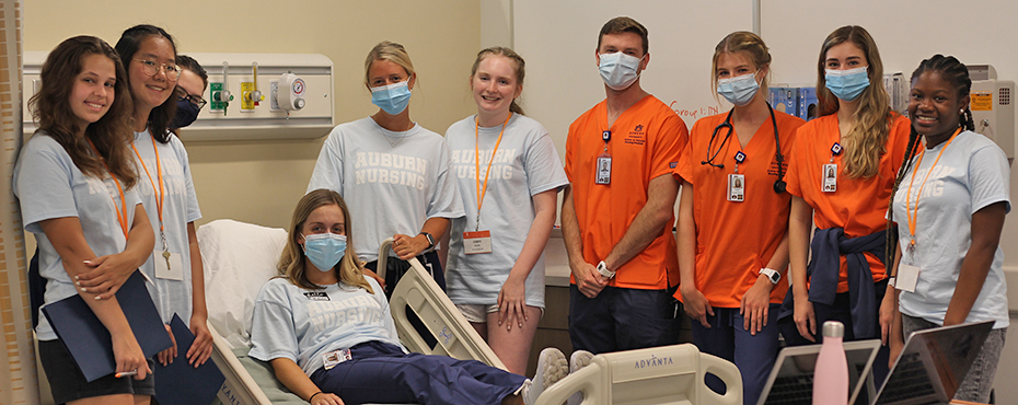 Students gathered around a hospital bed