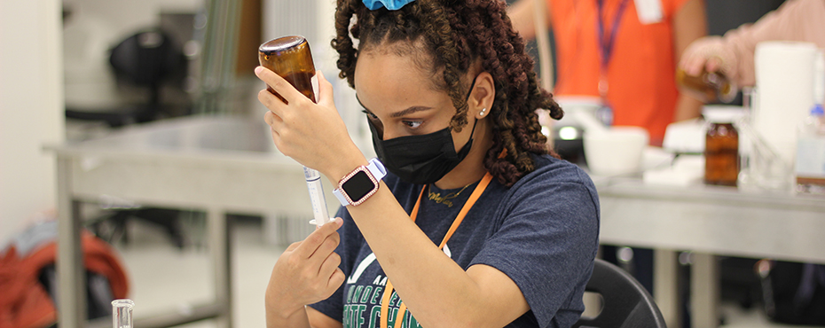 Student putting fluid in a syringe