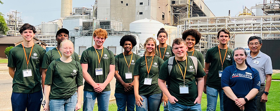 Group of campers listen to an instructor demonstrate how paper is made inside a research laboratory