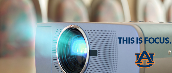 close up picture of a projector - it's on and there's a text overlay that says "this is focus"