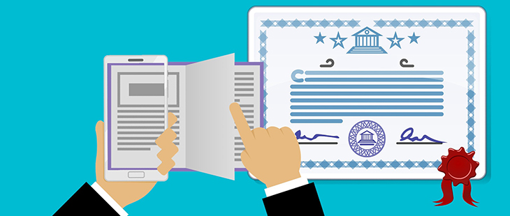 Hands holding a mobile device reading a book with a certificate of completion to the side