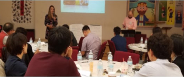 people sitting at round tables listening to a presentation