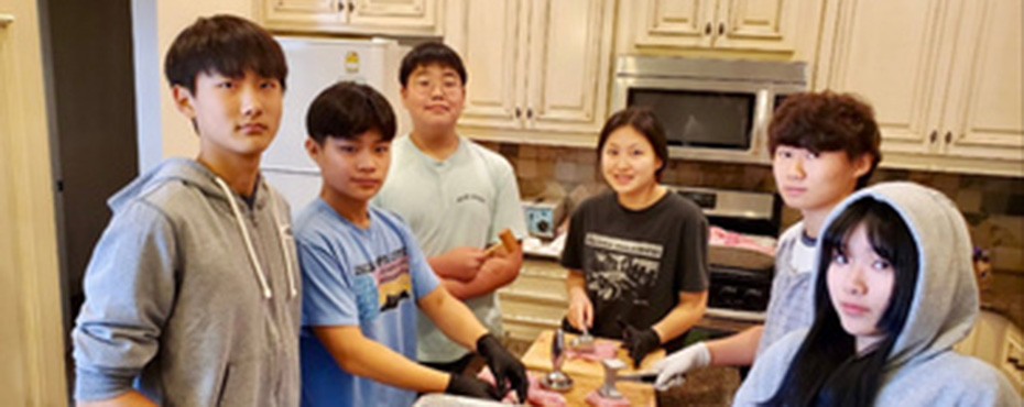 students meeting with a mentor around a kitchen counter
