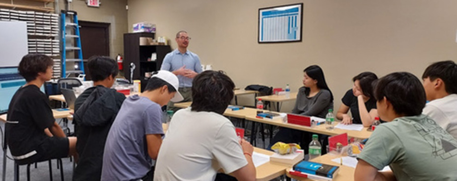 students sitting around tables in a classroom
