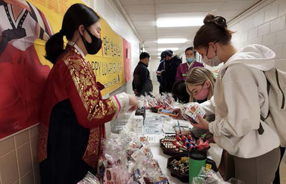 people at a display table in a hallway