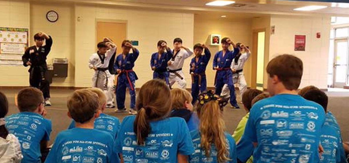group of martial arts students perform in front of onlookers