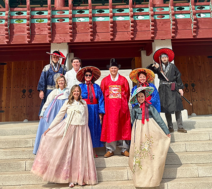 Group of people standing on stairs outside in native attire