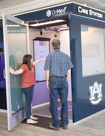 Stand alone OnMed medical unit with two people about to enter for a medical exam