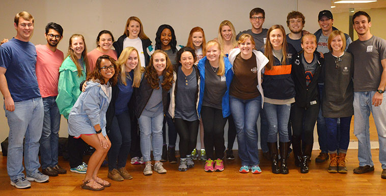 Group of Campus Kitchen student volunteers standing by wall and posing for picture