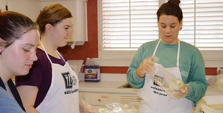 Students learning how to re-package food for distribution